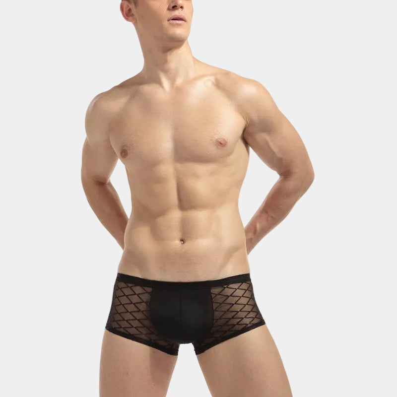 Man wearing black fishnet underwear on a white background