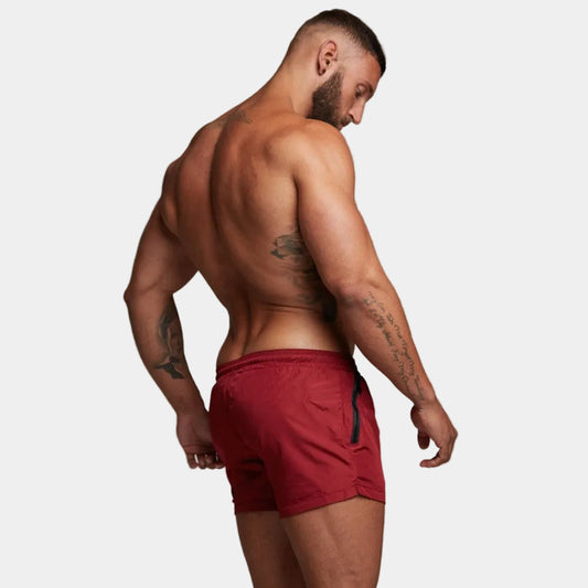 Man wearing red shorts against a gray background