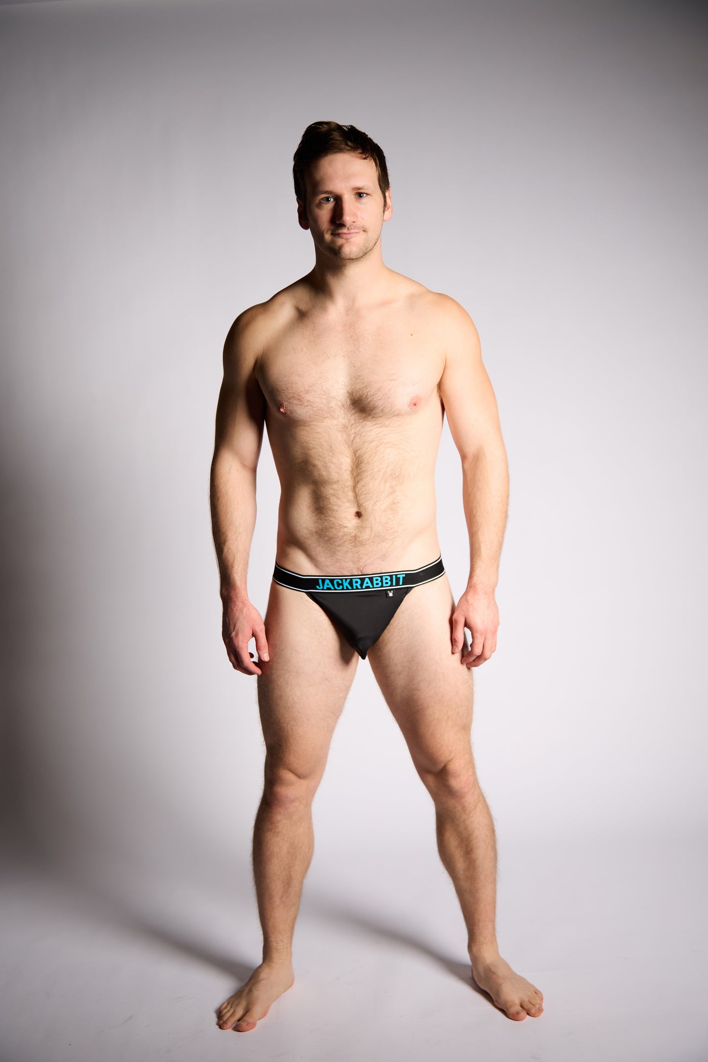 Man wearing a black underwear with 'Jackrabbit' branding on a gray background