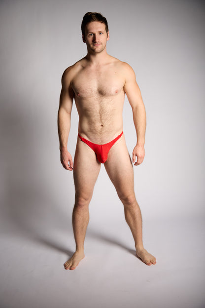 Man wearing a red swimsuit against a gray background