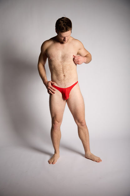 Man wearing a red underwear on a plain background