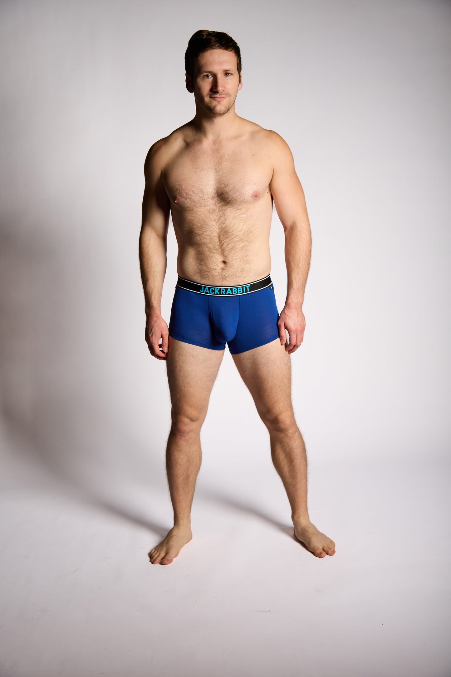 Man wearing blue underwear on a plain background