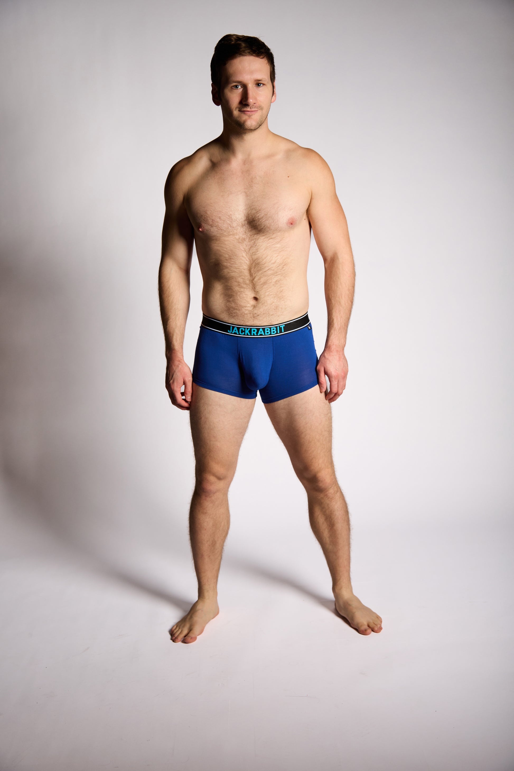 Man wearing blue underwear on a plain background