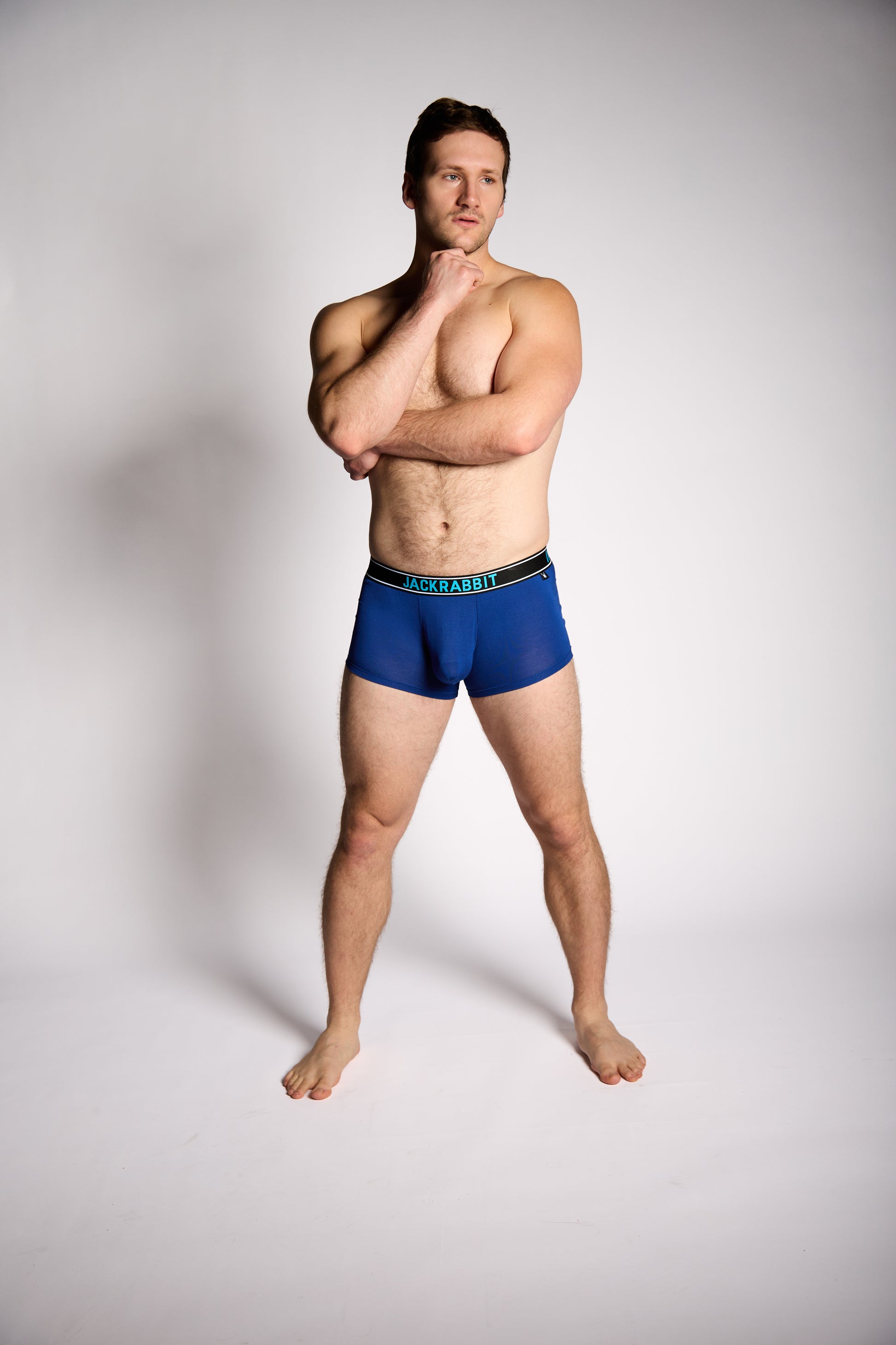 Man wearing blue underwear on a plain background