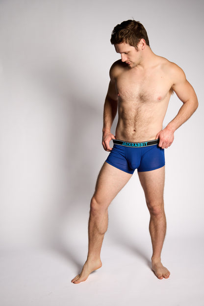 Man wearing blue boxer briefs on a plain background