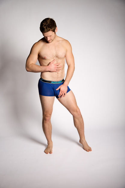 Man wearing blue underwear on a plain background