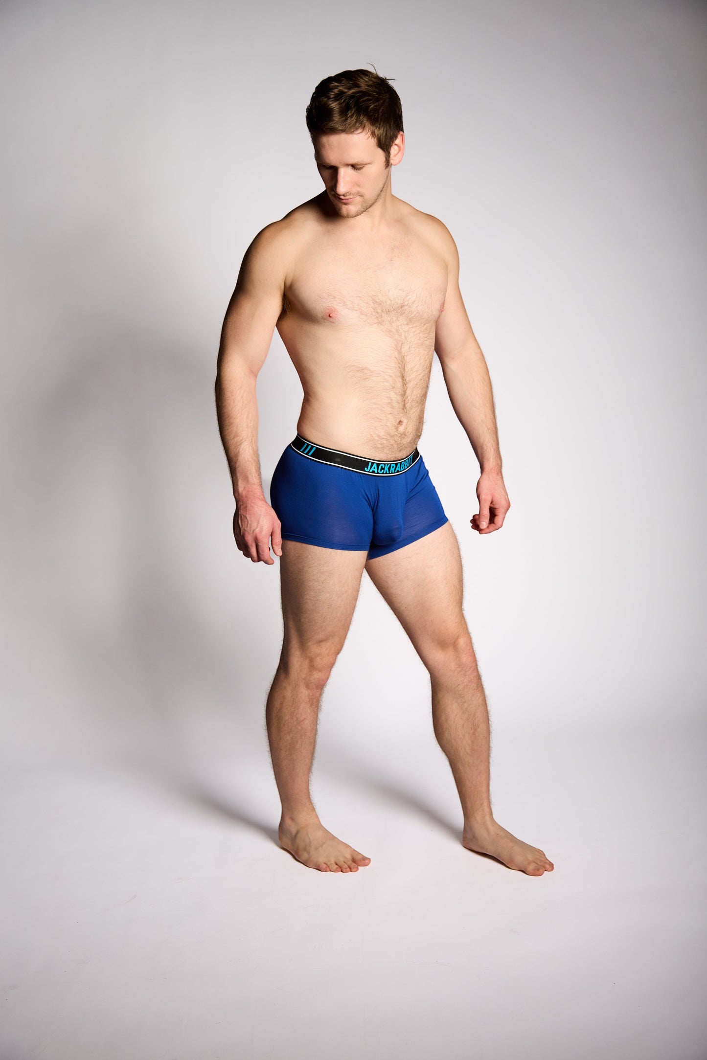 Man wearing blue underwear on a plain background